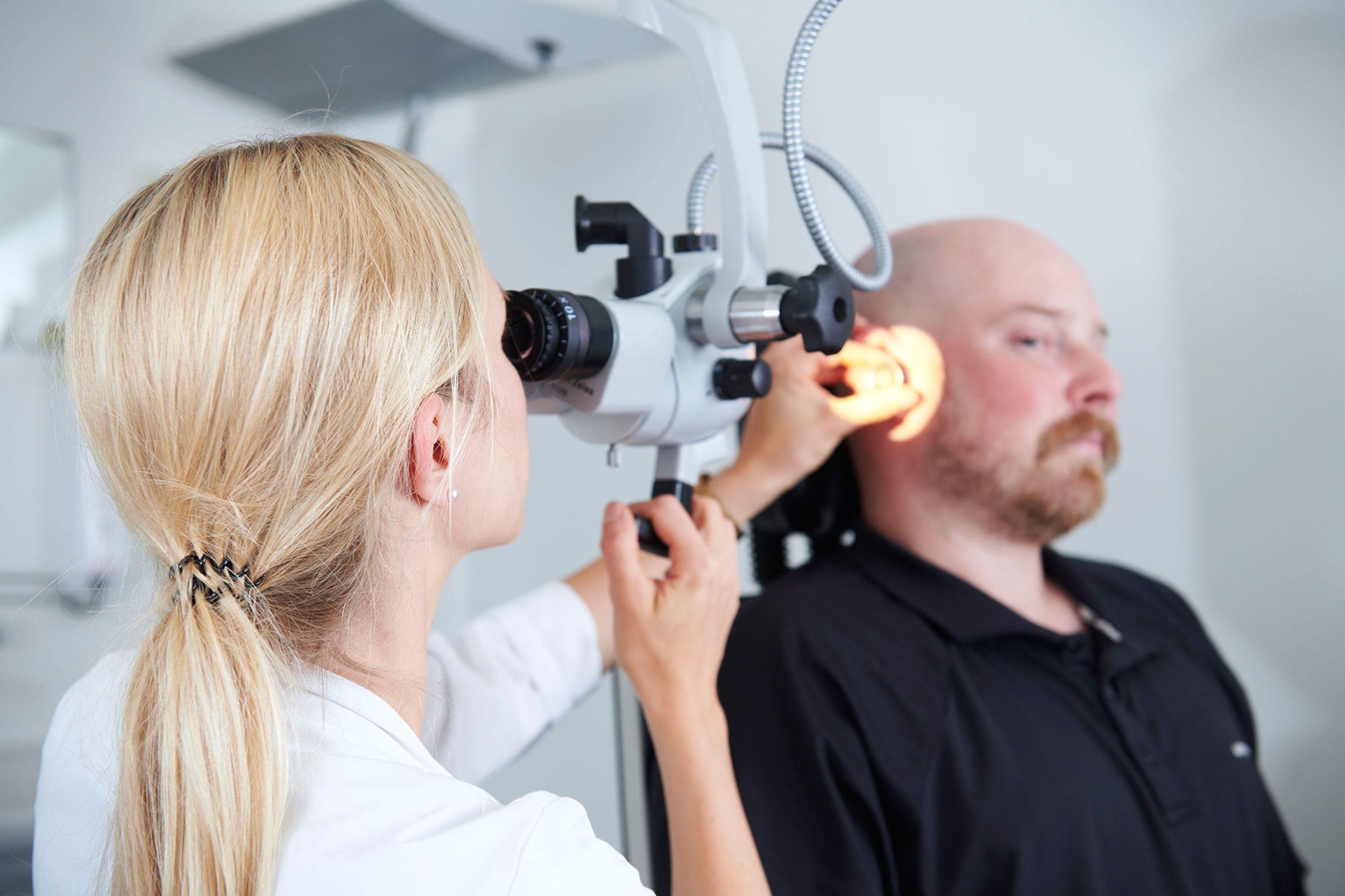 Doctor examines patient's ear