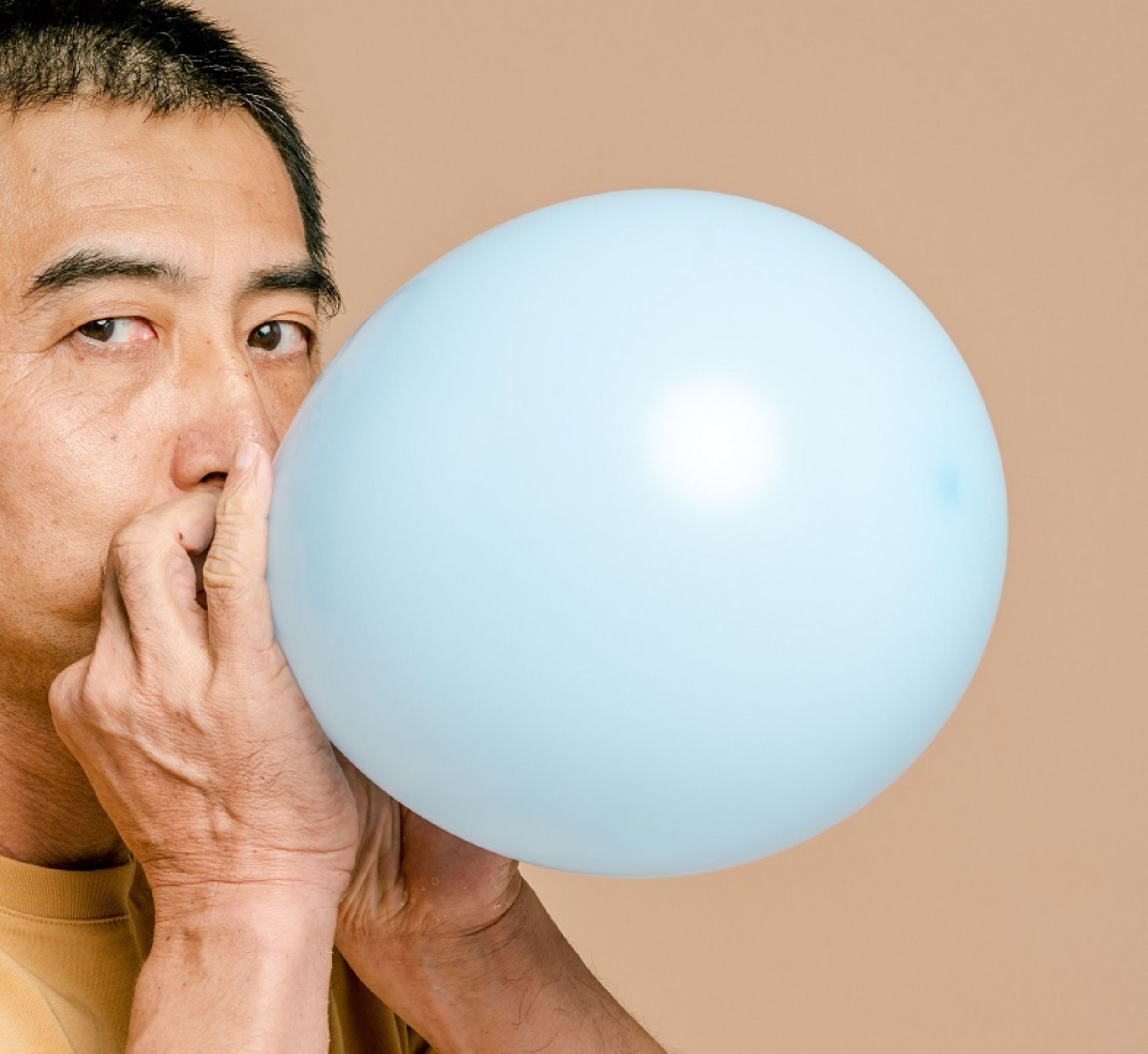 Mann bläst Ballon auf