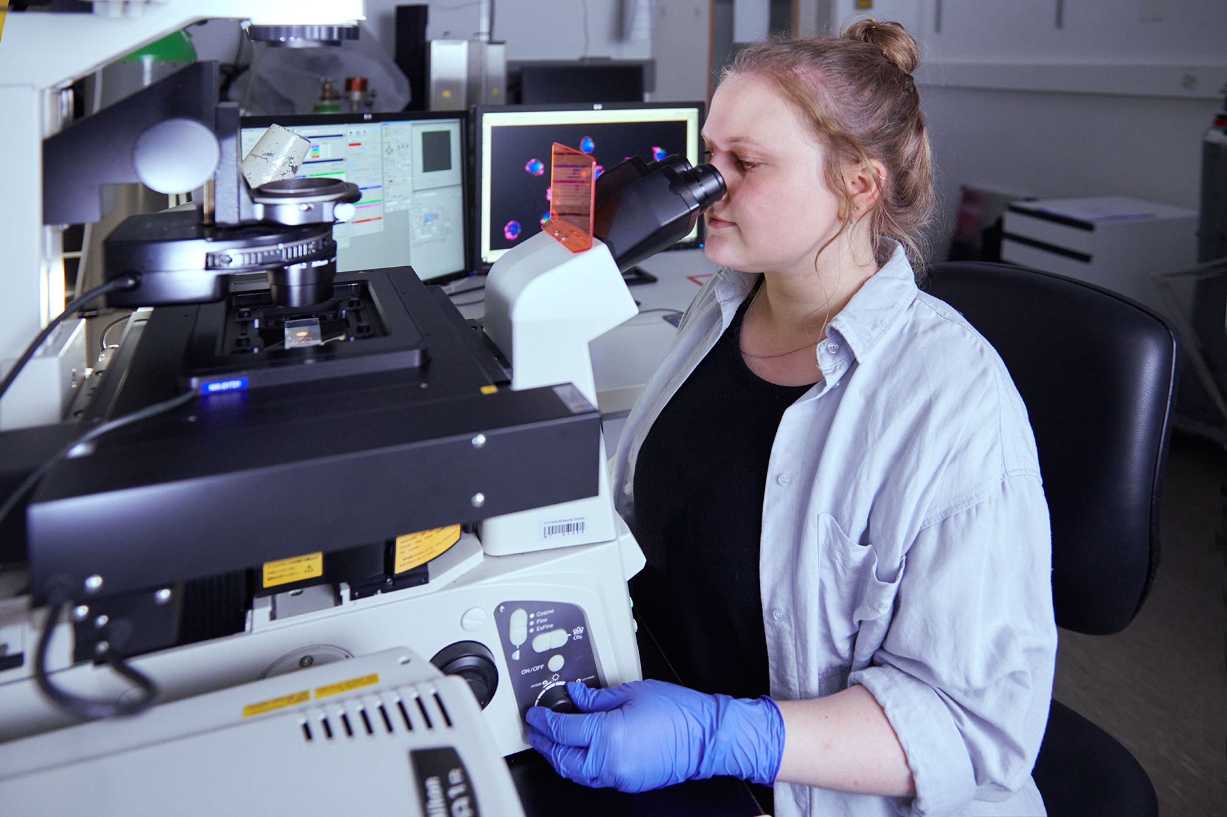 Chercheuse au microscope dans un laboratoire