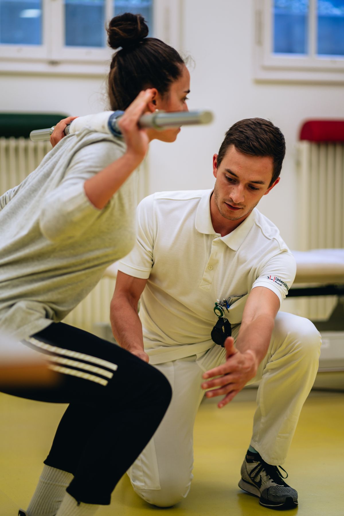 Physiotherapist does back exercises with patient